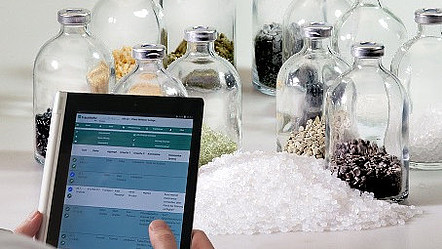 Ein Tablet mit Daten vor mehreren Glasflaschen mit unterschiedlichen Inhalten
