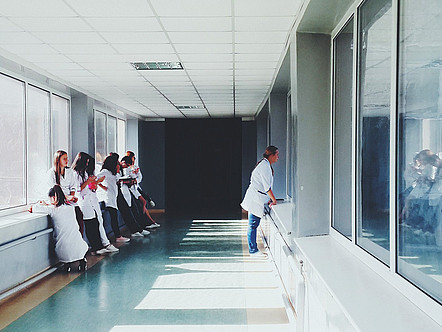Ein Gang in einem Krankenhaus mit jungen angehenden Ärzt*innen