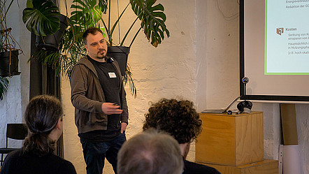 Projektpartner Dennis Junger (HTW) steht auf der Bühne und hält seinen Vortrag