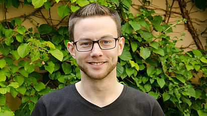 Portraitbild von Marc-André Kaufhold vor einem neutralen Hintergrund. 