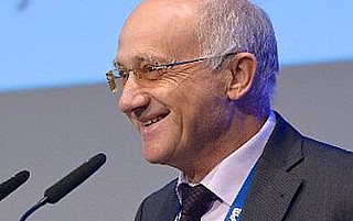 Portraitfoto von Prof. Dr. Harald Wehnes vor grauem und blauem Hintergrund