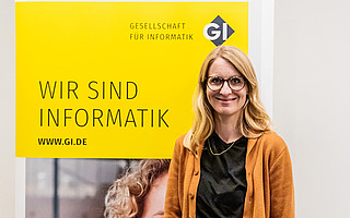 Portraitfoto von Anna Lieckfeld vor GI-Hintergrund mit Text "Wir sind Informatik"