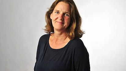 Portrait von Ute Schmid in einem schwarzen Oberteil. Sie blickt lächelnd in die Kamera.