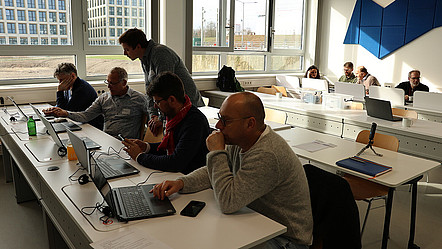Impression des Workshops: 5 Personen an Laptops