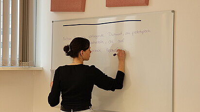 Impression des Workshops: Eine Person schreibt etwas an ein Whiteboard.