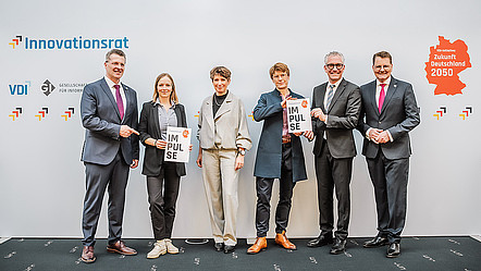 Sieben Personen präsentieren die Broschüre „Impulse“ des Innovationsrats vor einer Pressewand mit den Logos von Innovationsrat, VDI und GI sowie der Initiative „Zukunft Deutschland 2050“.