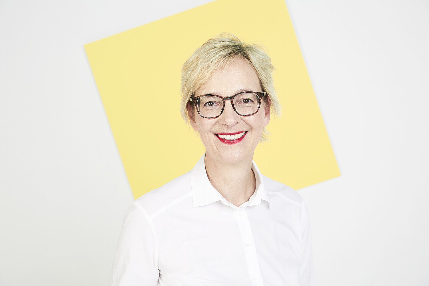 Porträt von Christine Regitz vor einer gelben quadratischen Fläche